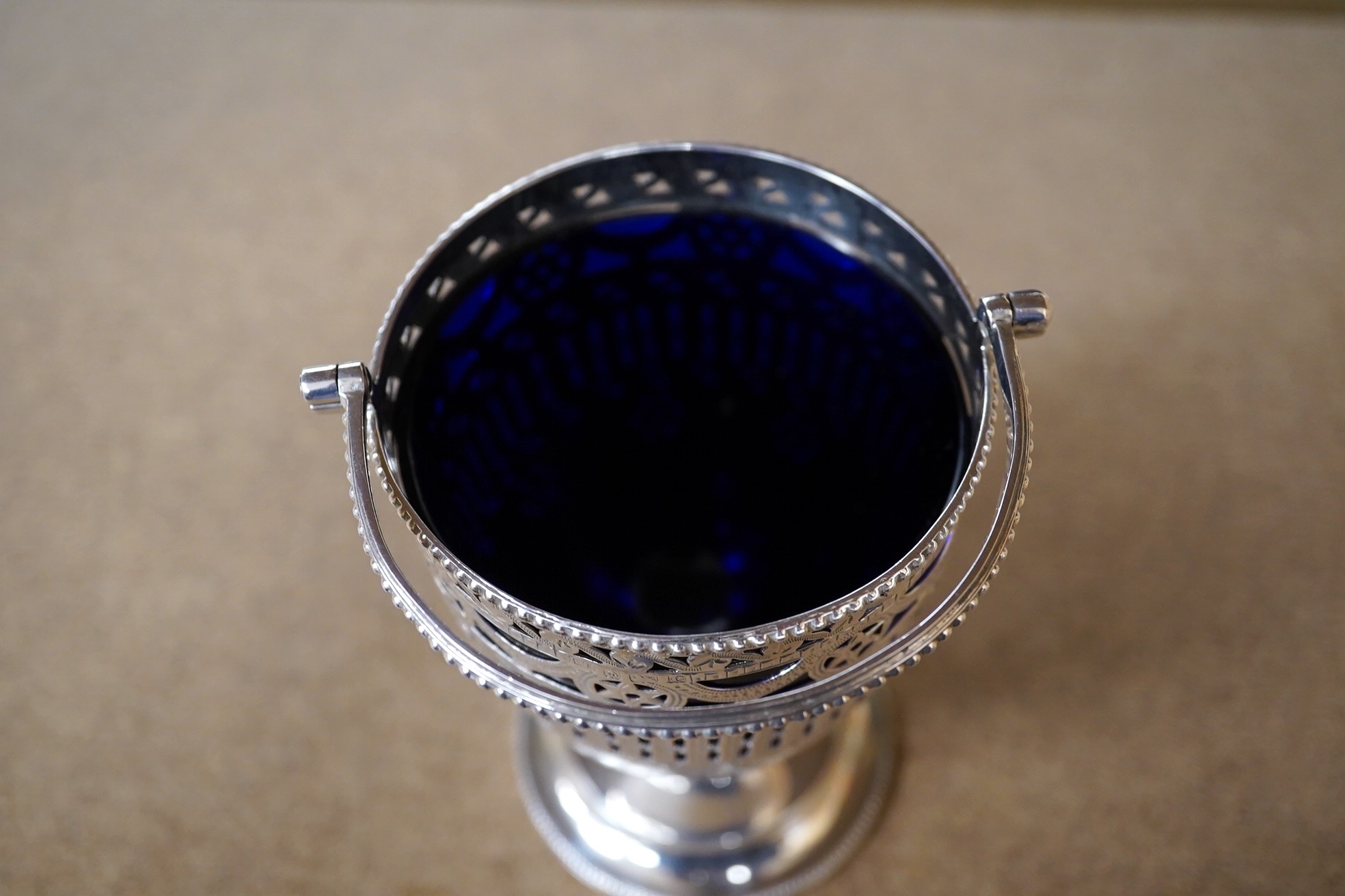 An Edwardian pierced silver pedestal sugar basket, with later? blue glass liner, Thomas Hayes, Birmingham, 1904, 11.7cm. Condition - fair to good